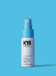 K18 AstroLift hair spray bottle on a blue background