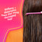 Person with long hair using a pink comb against a pink background with text about hair care.