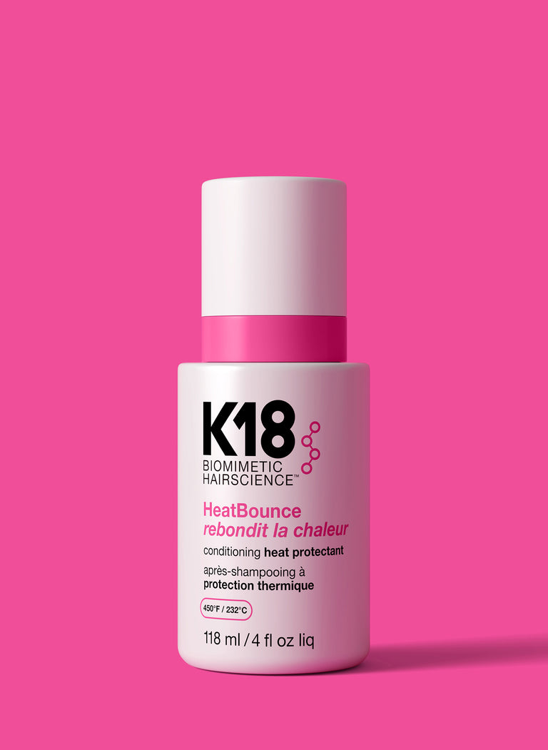 k18-heatbounce-conditioning-heat-protectant-bottle-on-a-pink-background