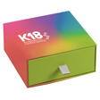 A medium-sized gift box with a colorful gradient design and a green drawer with a silver handle. The box is labeled with the brand 'K18'.